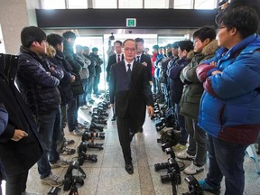 South Korean photographers lay their cameras on the ground in protest against the defence ministry's decision not to allow them to take pictures of the signing of a South Korea-Japan military intelligence exchange treaty as Japanese Ambassador to Seoul Yasumasa Nagamine (C) enters the ministry for the signing ceremony in Seoul on November 23, 2016. (AFP PHOTO)