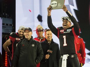 Henry Burris raises his MVP plaque following Sunday's RedBlacks Grey Cup win over the Stampeders in Toronto. (Laura Pederson)