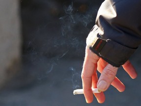 A man holds a smoking cigarette near Belleville city hall on Friday December 11, 2015 in Belleville, Ont. Tim Miller/Belleville Intelligencer/Postmedia Network