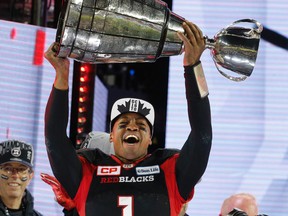 Redblacks quarterback Henry Burris hoists the Grey Cup. (Michael Peake, Postmedia Network)