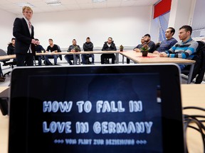 In this Nov. 22, 2016 photo refugees take part in a flirt workshop called 'how to fall in love in Germany" in Dortmund, Germany. Teacher Horst Wenzel, left, who usually teaches German men how to approach women, volunteers his skills to help with integrating some of the more than 1 million refugees who have arrived over the past two years in Germany. (AP Photo/Michael Probst)