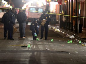 A crime scene technician collects evidence from the street as New Orleans Police investigate a fatal shooting at Iberville and Bourbon streets early Sunday, Nov. 27, 2016, in New Orleans. (Michael DeMocker/NOLA.com The Times-Picayune via AP)