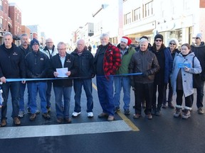 BRUCE BELL/The Intelligencer
Prince Edward County mayor Robert Quaiff, surrounded by council members, staff and members of the Picton Business Improvement Association, gets ready to cut the ribbon to officially re-open Picton's Main Street after a massive revitalization project. The street opened just in time to welcome Santa Claus for the town's annual parade on Sunday afternoon.