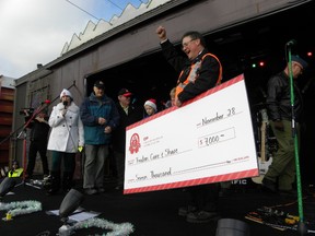 Ernst Kuglin/The Intelligencer
CP Holiday Train train master Dave Clifford presented Trenton Care and Share Food Bank manager with a $7,000 donation Monday morning. Several hundred people were at the RCAF Road level crossing for the annual Christmas event.