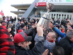 Redblacks coach Rick Campbell joins the fans for a celebration with the Grey Cup. (Jean Levac, Postmedia Network)