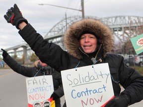 Pam Domenichini and fellow workers of the Blue Water Bridge picket at the bridge administration building, next to the span between Sarnia and Port Huron, Michigan on Monday, Nov. 21, 2016, in Sarnia, Ontario. A strike at Canada's second-busiest commercial border crossing to the United States has entered its second week. (THE CANADIAN PRESS/Dave Chidley)