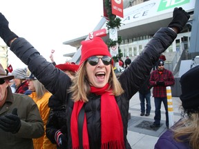 A Redblacks fan waits for the team to arrive at TD Place on Monday. The Ottawa Sun’s Bruce Garrioch listened to the final moments of the big game with media colleagues on a web-based radio app. (JEAN LEVAC/POSTMEDIA NETWORK)
