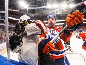 Milan Lucic takes Coyotes' Connor Murphy into the boards during Sunday's loss at Rogers Place. Head coach Todd Nelson gave the players the day off Monday. (The Canadian Press)