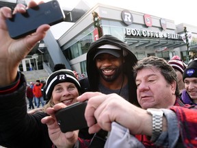 Ottawa Redblacks' Ernest Jackson poses for photos with fans after the team returned to Ottawa after winning the Grey Cup against the Calgary Stampeders, on Monday, Nov. 28, 2016. (THE CANADIAN PRESS/Justin Tang)