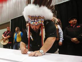 Chief Cameron Catcheway, Skownan First Nation, signs The Treaty Alliance Against Tar Sands Expansion at a Special Chiefs Assembly/Conference on Climate Change and the Environment in Winnipeg on Tuesday. Some Manitoba chiefs took part in a ceremonial signing of The Treaty Alliance Against Tar Sands Expansion. (THE CANADIAN PRESS/John Woods)