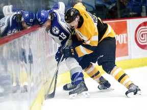 Kingston Frontenacs defenceman Jacob Paquette and Wolves forward Michael Pezzetta fight for the puck during OHL action at the Sudbury Community Arena on Nov. 20. Paquette says the Frontenacs have to play with intensity against the Ottawa 67’s Wednesday night. (Gino Donato/Postmedia Network)