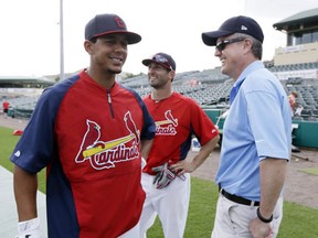 In this Feb. 25, 2013, file photo, Houston Astros general manager Jeff Luhnow, right, talks to St. Louis Cardinals center fielder Jon Jay, left, and second baseman Daniel Descalso before an exhibition spring training baseball game in Jupiter, Fla.