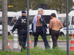 In this Monday, Oct. 5, 2015 file photo, Air France director of Human Resources Xavier Broseta, right, and Air France assistant director of long-haul flights Pierre Plissonnier, center, are protected by a police officer as they flee Air France headquarters at Roissy Airport, north of Paris, France, after scuffles with union activists. Fifteen current and former Air France workers are awaiting a verdict in a case of alleged violence during a union protest last year at the airline's headquarters that saw two company executives flee over a fence with their shirts ripped off. (AP Photo/Jacques Brinon, File)