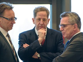 Hans-Georg Maassen, head of Germany's domestic intelligence service, center, listens to Interior Minister Thomas de Maiziere, right, and the head of Germany's Federal Criminal Police Office, BKA, Holger Muench, left, during a meeting of interior ministers of German federal states, in Saarbruecken, Germany, Wednesday Nov. 30, 2016. Germany's domestic intelligence service says an employee suspected of trying to pass along sensitive material to Islamic extremists had only been working for the agency for a short time. (Oliver Dietze/dpa via AP)