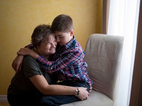 Sean Bellefeuille, 13, embraces his mother Dawn at their home in Ottawa, Saturday, Nov. 26, 2016. THE CANADIAN PRESS/Justin Tang