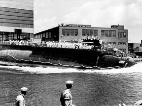 In this July 9, 1960 file photo the 278-foot (82 meters) long nuclear powered attack submarine USS Thresher, a first in its class boat, is launched bow-first at the Portsmouth Navy Yard in Kittery, Maine. A Navy submarine that left a Connecticut base this week is carrying the ashes of a veteran to be buried at sea near the site of the USS Thresher's sinking. For half a century Navy Capt. Paul "Bud" Rogers struggled with feelings that it should have been him and not his last-minute replacement on the doomed voyage. (AP Photo, File)