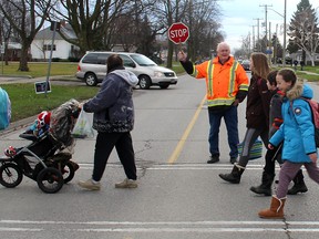 Crossing guard Jim Cracknell talks with some Dresden Area Central School students in Dresden Ont., on the last official day working for the Municipality of Chatham-Kent crossing guard program on Wednesday November 30, 2016. (Ellwood Shreve/Chatham Daily News)