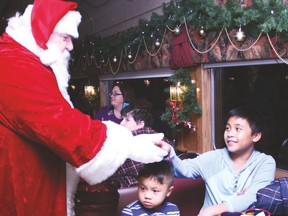 Santa Claus gives 12-year-old Brixx Antonio a sleigh bell during the Polar Express train ride at Aspen Crossing Railway Thursday, Nov. 24. Jasmine O'Halloran Vulcan Advocate