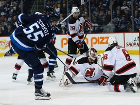 Mark Scheifele (55) scores on New Jersey Devils goaltender Cory Schneider (35) as Damon Severson (28) and Andy Greene (6) defend during second-period action on Tuesday night. (THE CANADIAN PRESS/John Woods)
