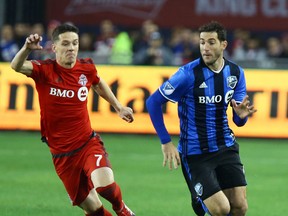 Toronto FC’s Will Johnson, seen here battling Montreal’s Ignacio Piatti last night, is one of 32 Canadians playing in MLS. (DAVE ABEL/Toronto Sun)