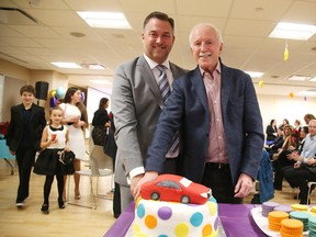 Vince Palladino and his dad Vip cut a cake following an announcement Wednesday that the Palladino family donated $500,000 to NEO Kids. Gino Donato/Sudbury Star