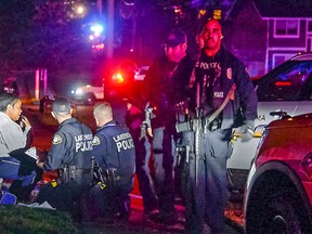 Police stand by a distraught Kristi Croskey at the scene where a Tacoma Police officer was shot while responding to a domestic call in East Tacoma, Wash., Wednesday, Nov. 30, 2016. Croskey was in the house with the shooter and fled. KCPQ-TV reports an officer was taken to a Tacoma hospital Wednesday after the incident at about 5:30 p.m. (Peter Haley/The News Tribune via AP