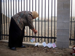 In this Dec. 4, 2015 file photo, Kareema Abdul-Khabir, who teaches special needs students at an elementary school in Barstow, Calif., places some cards made by her students at a makeshift memorial honoring the victims of a shooting rampage, in San Bernardino, Calif. In Dec. 2015, San Bernardino County health inspector Syed Farook and his Pakistan-born wife Tashfeen Malik opened fire on a meeting of Farook’s colleagues, and were killed in a shootout with police. In the aftermath of the terror attack in San Bernardino, Muslims in this Southern California community feared a prolonged, hate-filled backlash. While there were some incidents, for the most part, their worst fears never happened. (AP Photo/Jae C. Hong, File)
