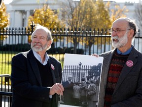 Michael, left, and Robert Meeropol, the sons of Ethel Rosenberg, pose similar to an old photograph of them, before they attempt to deliver a letter to President Barack Obama in an effort to obtain a pardon for their mother Ethel Rosenberg, in front of the White House, Thursday, Dec. 1, 2016 in Washington. (AP Photo/Alex Brandon)