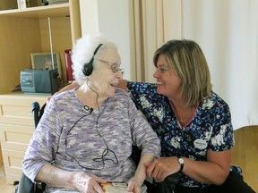 Woodingford Lodge resident Lois Smith (left) sits with Michelle Charlton, a personal support worker, as she listens to a musical playlist specifically curated for her through the Music & Memory program. (Submitted)