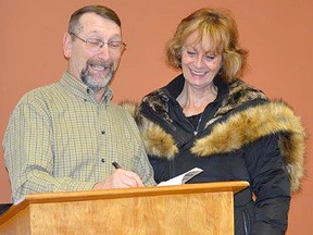 Michael O'Neill, local Lucknow author signs a copy of his new large print format book "Christmas Seasonings" for Joanne Vandam on Nov. 25, 2016 at the Lucknow Library. (Donna Hazelden photo)