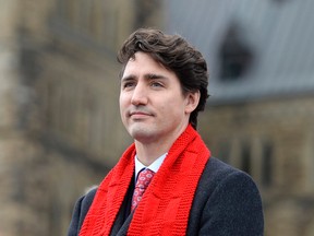 Prime Minister Justin Trudeau wears a scarf from the Red Scarf Project for AIDS awareness before raising the World AIDS Day flag in Ottawa on Thursday. (Justin Tang/The Canadian Press)