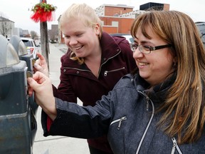 Luke Hendry/The Intelligencer 
Food for Learning co-ordinator Kellie Brace, right, and community development co-ordinator Vicky Struthers insert coins into parking meters on Pinnacle Street Thursday in Belleville. Feed the Meter is an annual campaign supporting the school nutrition program.