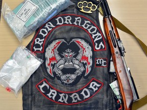 BELLEVILLE POLICE PHOTO
A biker vest of the Iron Dragons biker gang and a gun sit with other seized items on a table in this police photo. Police seized the weapons, drugs and other items during a raid Wednesday in Belleville.