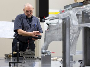 Leo Bourdeau uses a remote to control a coordinate measuring machine as he takes measurements of a beam, part of a Chrysler Jeep product, at Attica Manufacturing on Invicta Court in this file photo. (Free Press files)