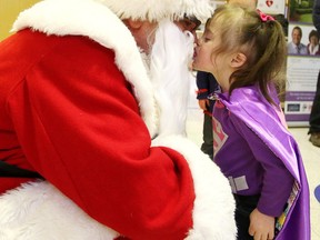 Three-year-old Kyra Fratin kisses Santa at the launch of the Northeastern Cancer Foundation's Calendar of Hope launch on Thursday. Kyra is featured in the month of May. Gino Donato/Sudbury Star