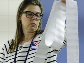 A worker looks over results during a statewide presidential election recount Thursday, Dec. 1, 2016, in Milwaukee. The first candidate-driven statewide recount of a presidential election in 16 years began Thursday in Wisconsin, a state that Donald Trump won by less than a percentage point over Hillary Clinton after polls long predicted a Clinton victory. (AP Photo/Morry Gash)