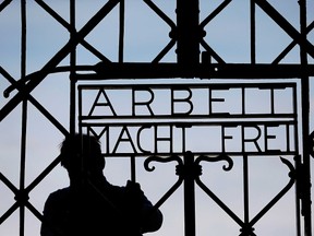 In this April 29, 2015 file picture a blacksmith prepares a replica of the Dachau Nazi concentration camp gate, with the writing "Arbeit macht frei" (Work Sets you Free) at the main entrance of the memorial in Dachau, Germany,. (AP Photo/Matthias Schrader,File)