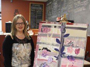 Local fine artist Pam St. Laurent stands beside her artwork at the first Gallery Evenings on Nov. 29 hosted by Brian’s House of Coffee. Gallery Evenings will continue to feature local artists every Tuesday night until Dec. 20.