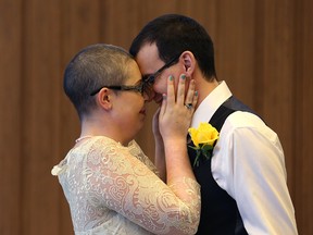Lisa Carson-Walton and Chris Herie embrace after being married during the first civil marriage at City Hall in Winnipeg on Fri., Dec. 2, 2016. (Kevin King/Winnipeg Sun/Postmedia Network)