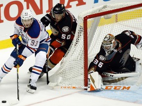 Edmonton Oilers center Ryan Nugent-Hopkins (93) controls the puck with Anaheim Ducks center Antoine Vermette (50) trailing and goalie John Gibson (36) watching during the third period of an NHL hockey game in Anaheim, Calif., Tuesday, Nov. 15, 2016. The Ducks won 4-1.