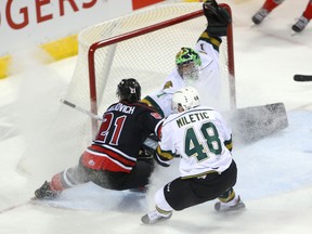 Jonah Gadjovich of the Owen Sound Attack and Sam Miletic of the Knights shower London goalie Tyler Parsons with snow as they fight for a rebound during the first period of their OHL game at Budweiser Gardens on Friday night. For the second time in nine days, the Attack won in a shootout. (MIKE HENSEN, The London Free Press)