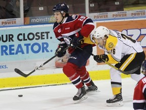 Saginaw Spirit forward Hayden Hodgson protects the puck from an errant stick and Sarnia Sting centre Franco Sproviero during the Ontario Hockey League game at Progressive Auto Sales Arena on Friday, Dec. 2, 2016 in Sarnia, Ont. Hodgson, who spent parts of three seasons in Sarnia, opened the scoring against his former team. (Terry Bridge/Sarnia Observer)