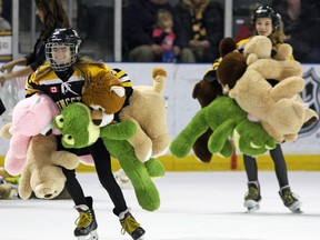Members of the Kingston Ice Wolves clean up after the annual Teddy Bear Toss for the Salvation Army at the Kingston Frontenacs game at the Rogers K-Rock Centre on Friday night. (Steph Crosier/The Whig-Standard)