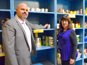 Greg Holmes, media sales manager of the Sarnia Observer, and Adelle Richards, operations manager of the Inn of the Good Shepherd, have a look at some shelves in their John Street Food Bank, which are always in need of a restock. Melissa Schilz/Postmedia Network