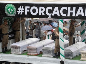 Trucks carrying the coffins with the remains of Chapecoense soccer team members, victims of an air crash in Colombia, drive through the streets of Chapeco, Brazil, Saturday, Dec. 3, 2016. (AP Photo/Andre Penner)