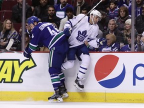 Canucks' Erik Gudbranson (left) checks Maple Leafs' Nazem Kadri (right) during first period NHL action in Vancouver on Saturday, Dec. 3, 2016. (Ben Nelms/The Canadian Press)