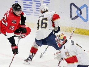 Senators forward Buddy Robinson (left) is checked off the puck by Florida Panthers’ Aleksander Barkov as goaltender Roberto Luongo looks on during the second period on Saturday night at the Canadian Tire Centre. Robinson was recalled from AHL Binghamton, where he has seven points in 18 games this season. (WAYNE CUDDINGTON/POSTMEDIA NETWORK)