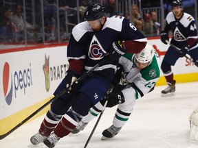 Avalanche defenceman Erik Johnson (left) tries to clear the puck from behind the team's net as Stars centre Radek Faksa (right) defends during the second period in Denver on Saturday, Dec. 3, 2016. Johnson was injured later in the period after blocking a shot and did not return. (David Zalubowski/AP Photo)