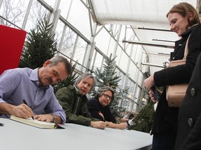 Chris Hadfield signs a book for Emma Nicholson, as illustrators Terry and Eric Fan look on. Hundreds showed up for the book-signing event at DeGroot's Nurseries Saturday. Tyler Kula/Sarnia Observer/Postmedia Network
