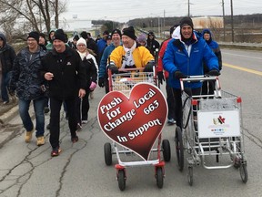 Joe Roberts with Push for Change, in blue, walks north on Indian Road Saturday in Sarnia, surrounded by members of United Association Local 663 - including Bob Sauve in yellow and Ross Tius, beside Sauve, in black. Roberts is trying to raise funds and awareness to help end youth homelessness in Canada. (Handout)